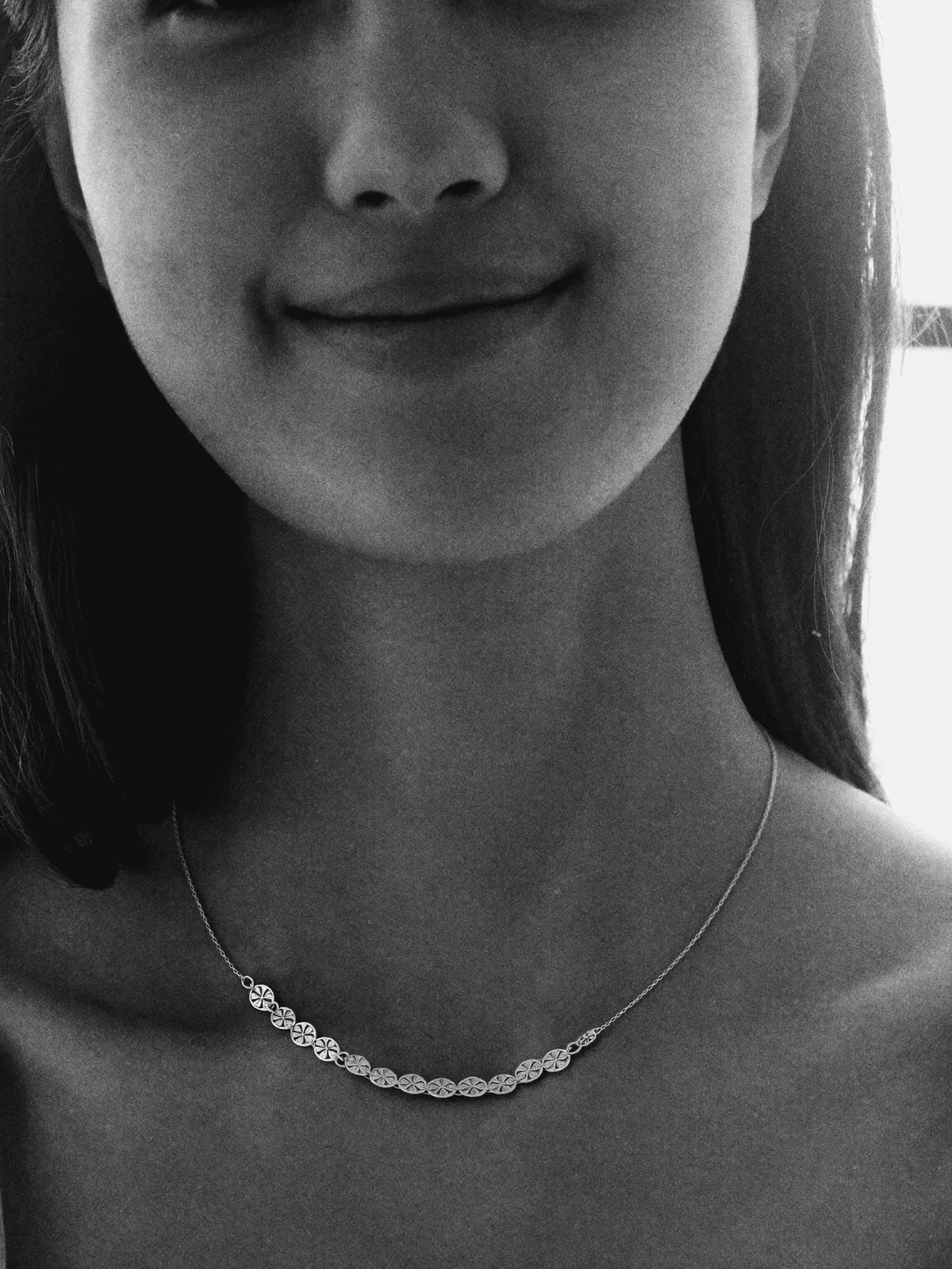 BW close gentle smile, silver station necklace