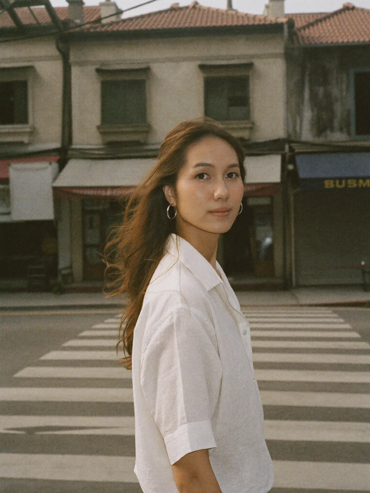 Mid-stride on a crossing, a single silver hoop earring